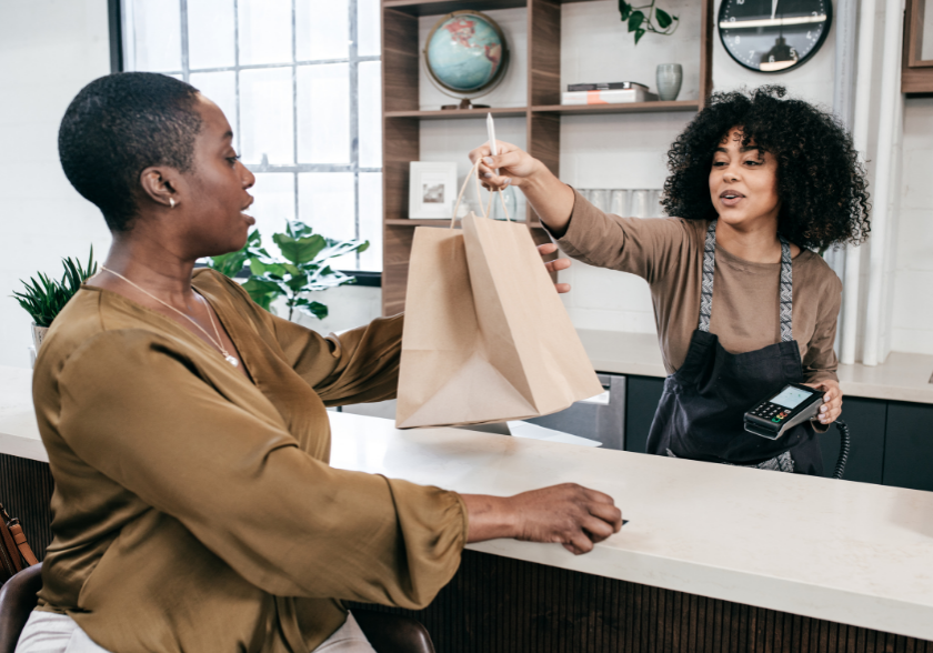Sales clerk handing a customer a bag