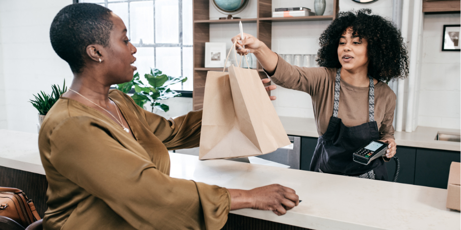 POS Image Sales clerk handing a customer a bag